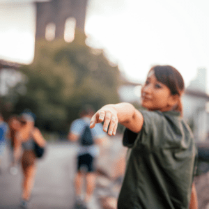 Person reaching their hand out and looking backwards towards camera