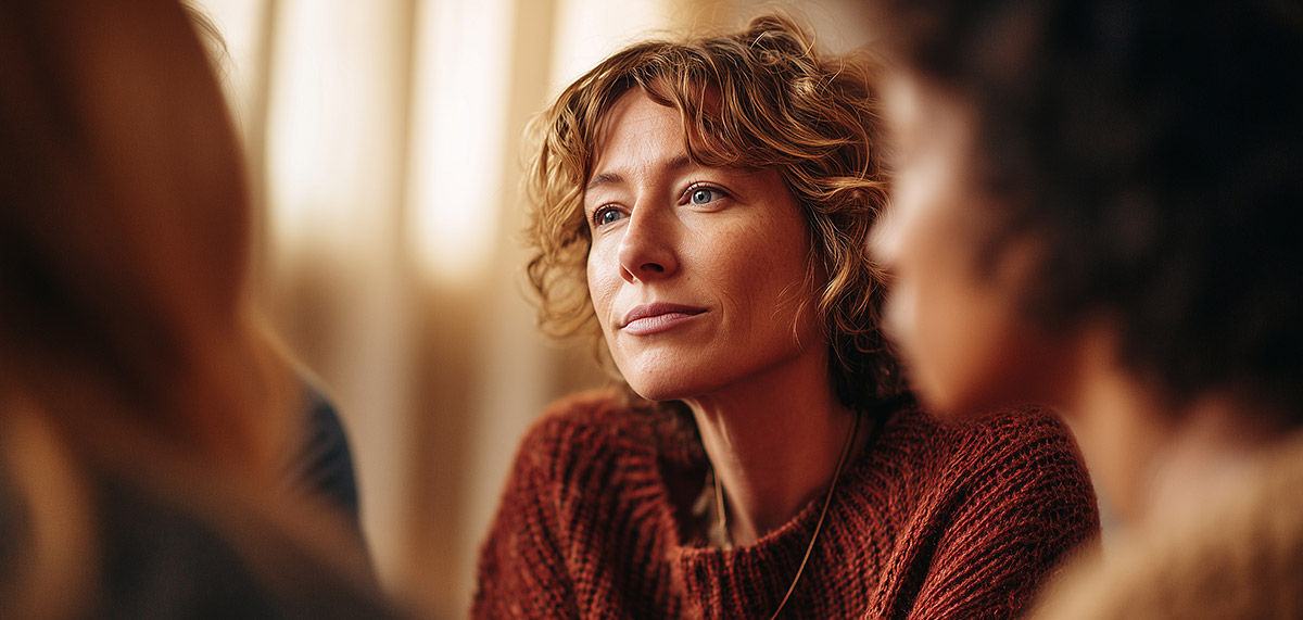 WIL Placements Benefit Everyone Thoughtful woman in a cozy rust sweater listening in a supportive group